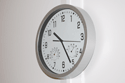 Eine Wanduhr symbolisiert die Öffnungszeiten.