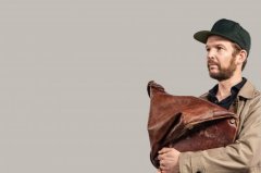 Bild zeigt Timo Wopp mit einer Kappe auf dem Kopf und eine Ledertasche in der Hand
