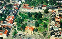 Das Bild zeigt eine Luftaufnahme der Stadt Hohenstein-Ernstthal mit mehreren Häusern und einem Park