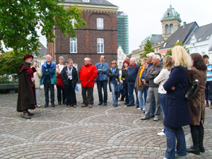 Eine Gruppe von Menschen die sich von einem Redner die Geschichte Rheinbergs anhören