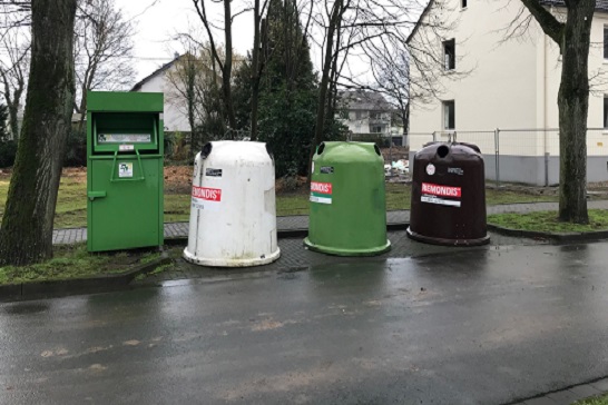 Ein weißer, brauner und grüner Glaßcontainer