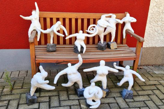Mehrere Kunstfiguren auf einer Bank