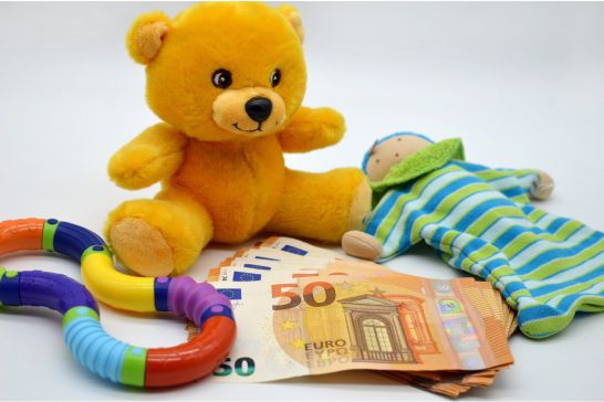 Ein Teddybär mit anderem Spielzeug und Geldscheinen