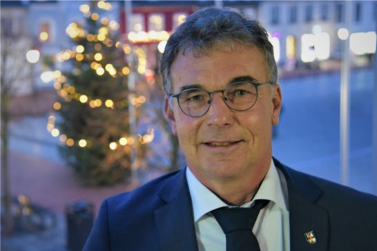 Bürgermeister mit Tannenbaum im Hintergrund
