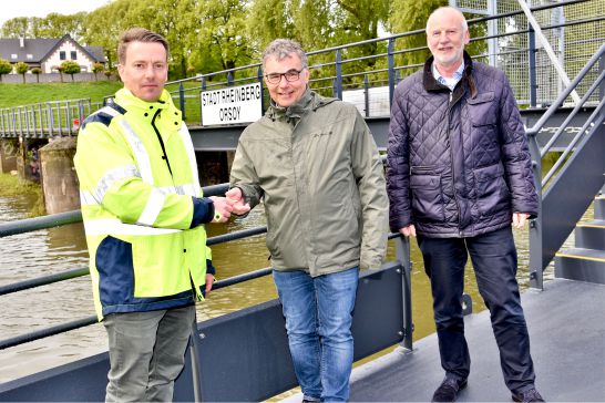 Foto: Stadt RheinbergBürgermeister Dietmar Heyde (Mitte) und Baudezernent Dieter Paus (rechts) nahmen am Tag der Montage den Schlüssel zum neuen Schiffsanleger in Orsoy von Otto Penner (links, Firma SBS Andernach) entgegen.